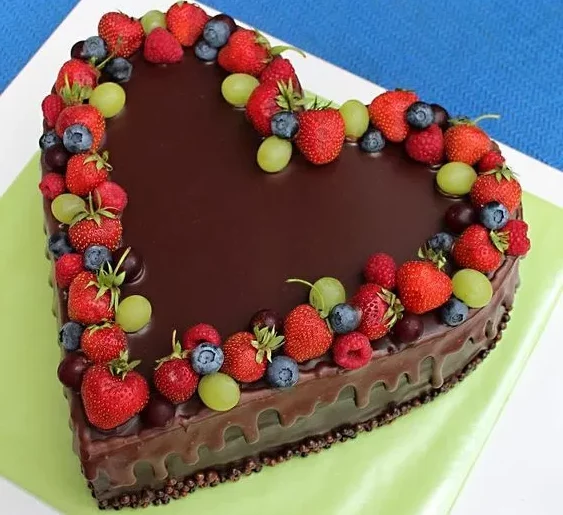 Bolo em formato de coração, decorado com chocolate e frutas