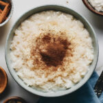 Equipamentos Necessários Panela grande Colher de pau ou silicone Ralador ou faca para casca de limão Modo de Preparo Cozinhando o Arroz Em uma panela grande, adicione o arroz e a água. Cozinhe em fogo médio até que o arroz absorva toda a água. Preparando o Creme Acrescente o leite, o leite condensado, o açúcar, a canela em pau e a casca de limão. Mexa bem. Cozinhe em fogo baixo por cerca de 20 minutos, mexendo sempre para não grudar. Quando o arroz estiver bem cremoso, desligue o fogo e retire a canela e a casca de limão. Finalização Transfira o arroz doce para uma travessa ou potes individuais. Polvilhe com canela em pó e sirva morno ou gelado. Dicas Extras Para um arroz doce ainda mais cremoso, utilize leite integral fresco. Se preferir, substitua o açúcar por adoçante culinário para uma versão menos calórica. O toque de limão equilibra o sabor e evita que fique enjoativo. Sugestões de Acompanhamento Canela em pau para decoração Paçoca esfarelada por cima para um toque crocante Um cafezinho fresco para harmonizar com o doce Como Armazenar Armazene o arroz doce em um recipiente fechado na geladeira por até 3 dias. Para reaquecer, adicione um pouco de leite e misture bem para recuperar a cremosidade. Considerações finais O arroz doce tradicional da vovó é uma sobremesa que traz memórias afetivas e um sabor incomparável. Com poucos ingredientes e um modo de preparo simples, você pode recriar essa delícia na sua casa e encantar sua família. Experimente hoje mesmo! FAQs Posso fazer arroz doce com arroz integral? Sim, mas o tempo de cozimento será maior e a textura ficará um pouco diferente, mais firme e menos cremosa. Como evitar que o arroz doce fique muito grosso? Se ele engrossar demais, adicione mais leite e misture bem até atingir a consistência desejada. Posso usar leite vegetal no lugar do leite de vaca? Sim! Leite de coco, amêndoas ou aveia são boas opções para uma versão sem laticínios. Como deixar o arroz doce ainda mais saboroso? Adicione cravo-da-índia ou leite de coco para um toque especial. É possível congelar arroz doce? Não é recomendado, pois a textura pode ficar granulada e perder a cremosidade.
